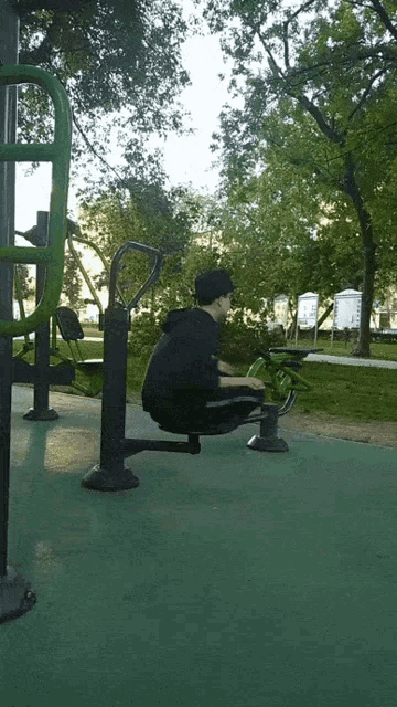 a man squatting on a green exercise machine