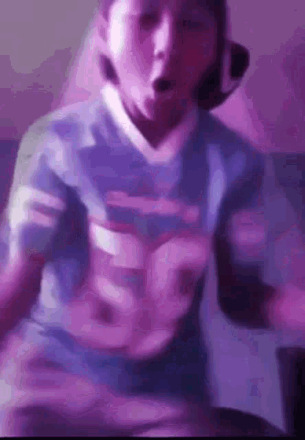 a young boy wearing a purple shirt and headphones is dancing in a room .