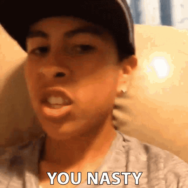 a young man wearing a hat and a gray shirt says you nasty