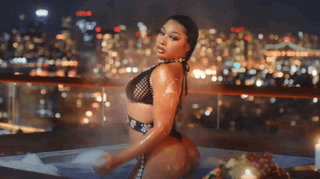 a woman in a black bikini is standing in a hot tub
