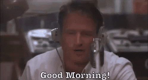 a man wearing headphones is sitting in front of a microphone and says `` good morning '' .