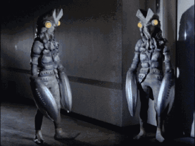two monsters are standing next to each other in a dark hallway