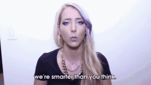 a woman with purple hair is making a funny face and says `` we 're smarter than you think '' .