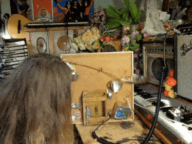 a woman is sitting in front of a microphone with a poster on the wall behind her that says stevie wonder