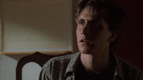 a young man with a cigarette in his mouth looks at something