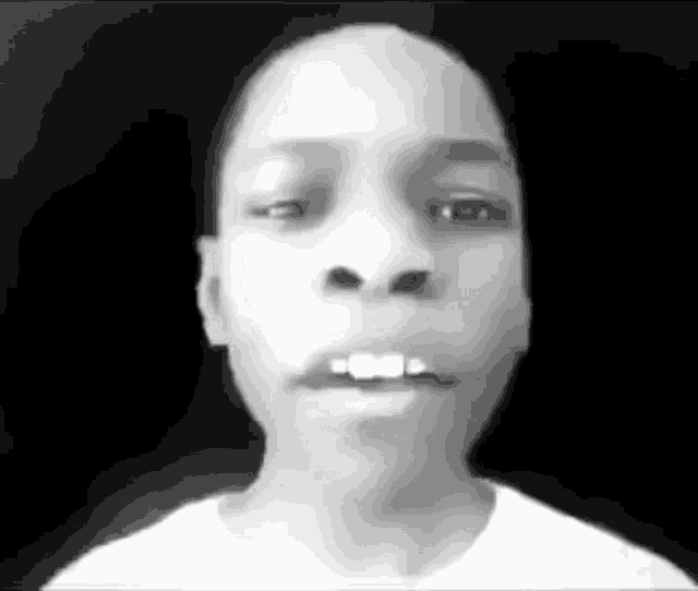 a black and white photo of a person 's face with a black background .