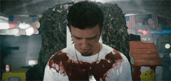 a man with blood on his shirt is wearing a military tag