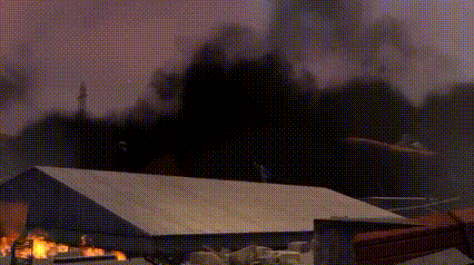 a building is on fire with smoke coming out of the roof .