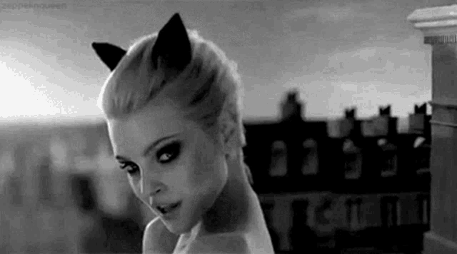 a black and white photo of a woman with cat ears on her head .
