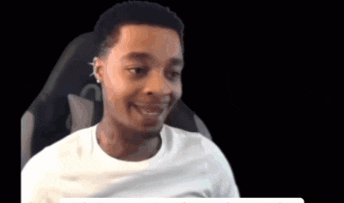 a man in a white shirt is smiling and looking at the camera