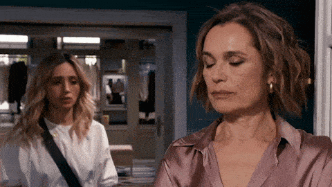 two women are standing in a room with their eyes closed