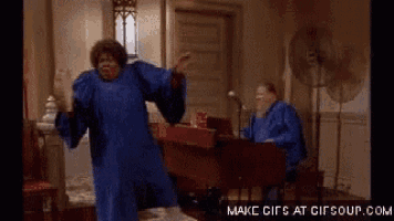 a woman in a blue gown is dancing in front of a piano .