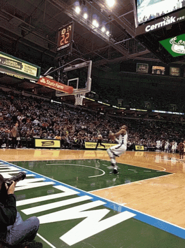 a basketball game is being played in a stadium with a state farm ad