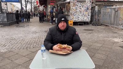 a man sits at a table with a bottle of water