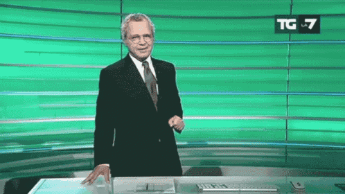 a man in a suit and tie is standing in front of a green screen that says tg 7 on it