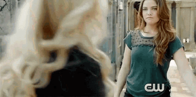two women are standing next to each other and looking at each other .