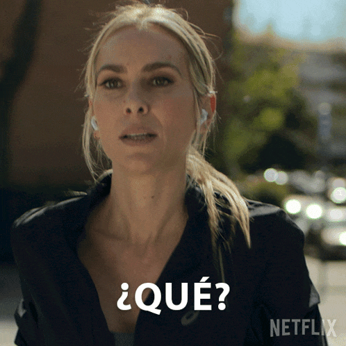 a woman wearing headphones says " qué " in spanish