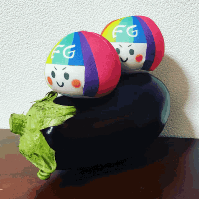 two stuffed eggs with the letters fg on them sit on top of an eggplant