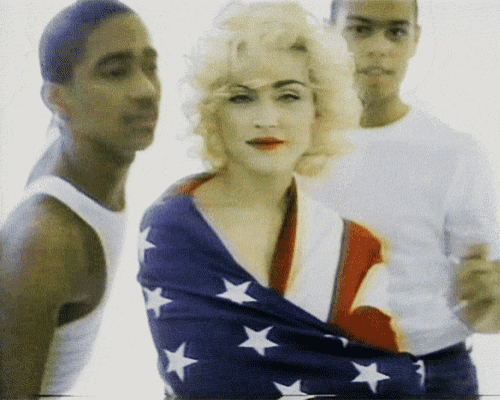 a woman is wrapped in an american flag while two men look on
