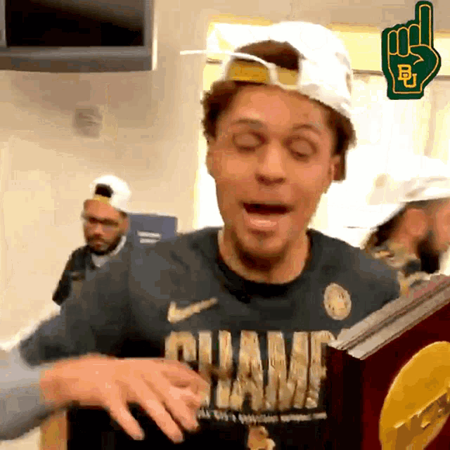 a man wearing a shirt that says " champ " holds a trophy