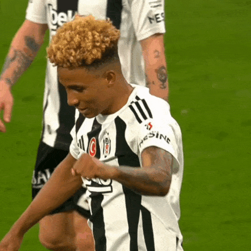 a soccer player wearing a black and white jersey that says nesline on the sleeve