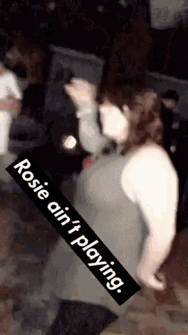 a woman is dancing with a sign that says rosie ain 't playing ..