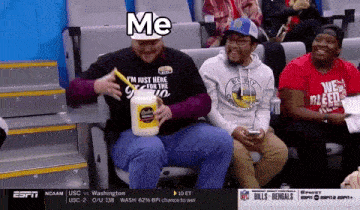 a man sitting in a stadium holding a bottle of mayonnaise and a straw with the word me on it