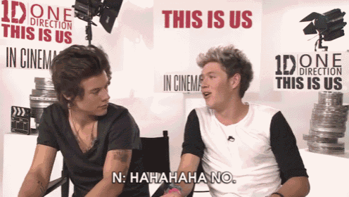 two guys are sitting in front of a wall that says this is us