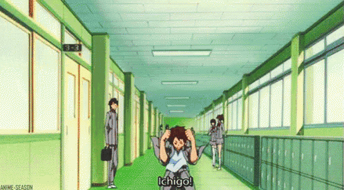a man is standing in a hallway with his hands on his head and says ichigo