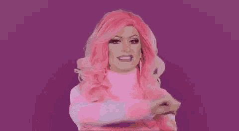 a drag queen with pink hair and a pink and white striped sweater is making a funny face .