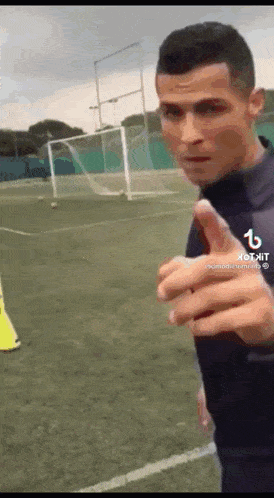 a man is giving a thumbs up on a soccer field .