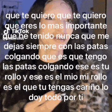 a woman is standing in front of a wall with a quote in spanish on it .