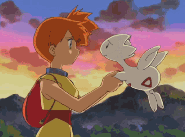 a girl holding a small white rabbit with a red triangle on its head