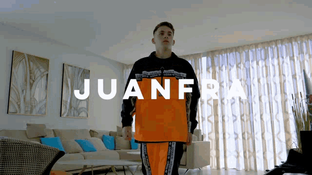 a man standing in a living room with the name juanfra on the bottom right