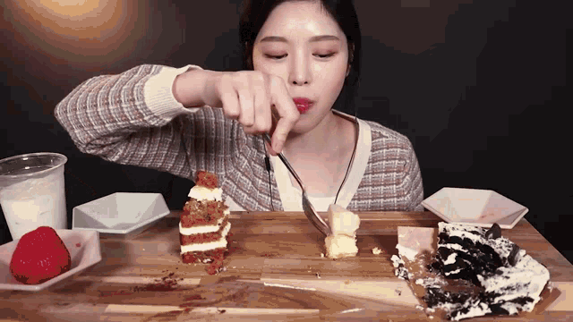 a woman is eating a cake with a fork