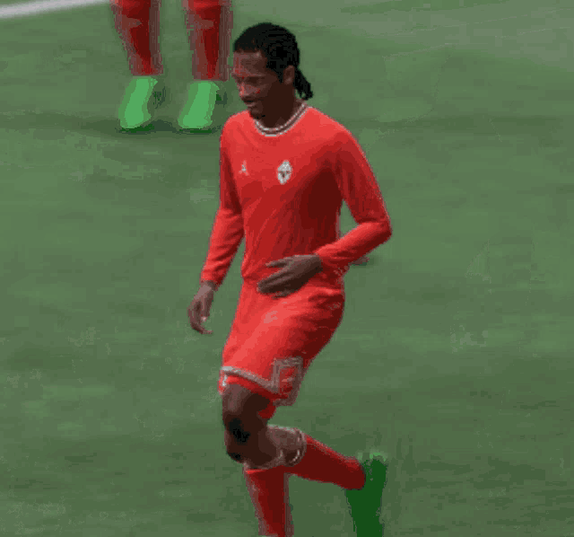 a soccer player wearing a red jersey with the number 2 on it