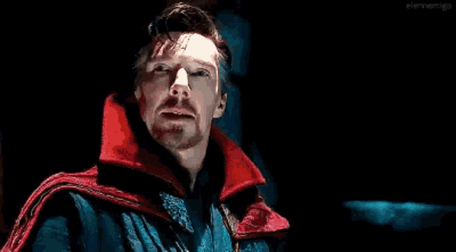 a close up of a man wearing a red cape and a blue jacket .