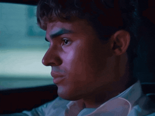 a close up of a man 's face looking out a car window