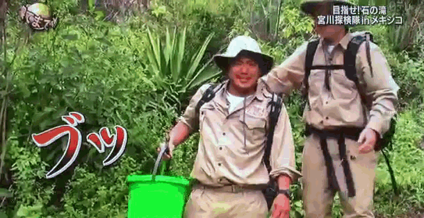 two men are standing next to each other and one is holding a green bucket ..