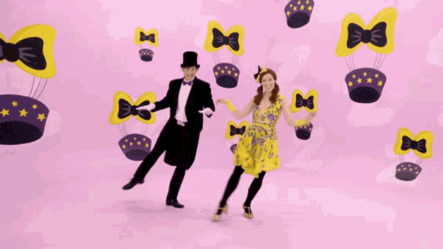 a man in a top hat and a woman in a yellow dress are dancing