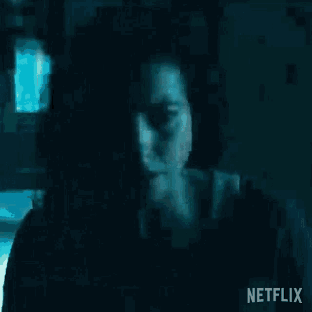 a close up of a woman 's face in a dark room with a netflix logo in the corner .