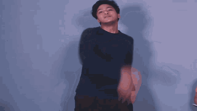 a man with his arms outstretched is wearing a black sweater