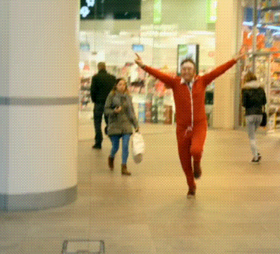a man in a red suit is running with his arms in the air