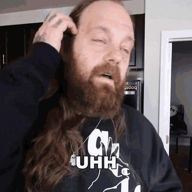 a man with a beard is wearing a sweatshirt that says uhh