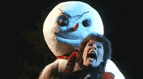 a man is screaming while standing next to a snowman in a dark room .