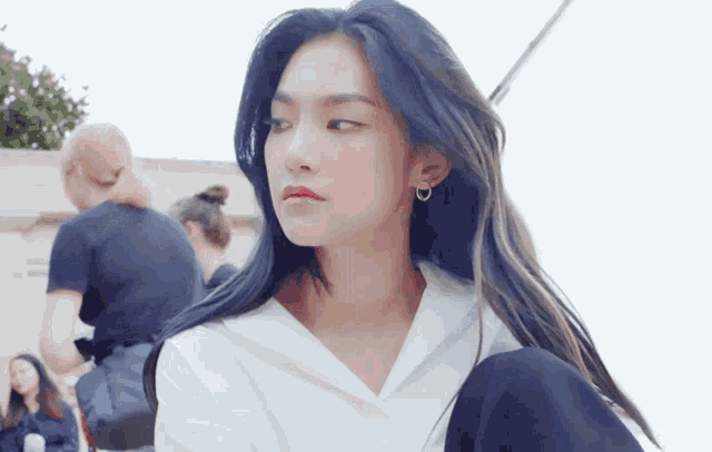 a woman with long blue hair is wearing a white shirt