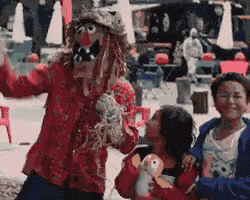 a scarecrow is posing for a picture with two children holding stuffed animals