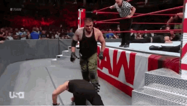 two men are wrestling in a wrestling ring with a sign that says raw on it .