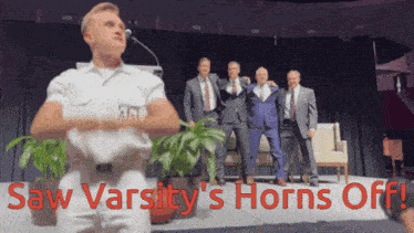 a group of men standing on a stage with the words saw varsity 's horns off in red