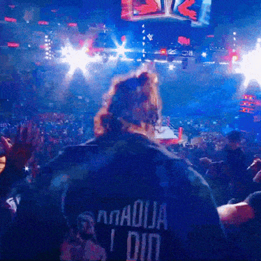 a man wearing a black shirt that says anadija i did stands in front of a crowd
